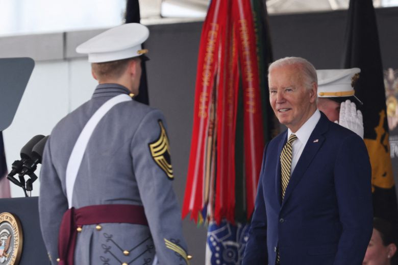 조 바이든 미국 대통령이 25일(현지시간) 미 육군사관학교 웨스트포인트 졸업식에서 한 졸업생에게 졸업장을 주고 격려하고 있다. [AFP·게티이미지]