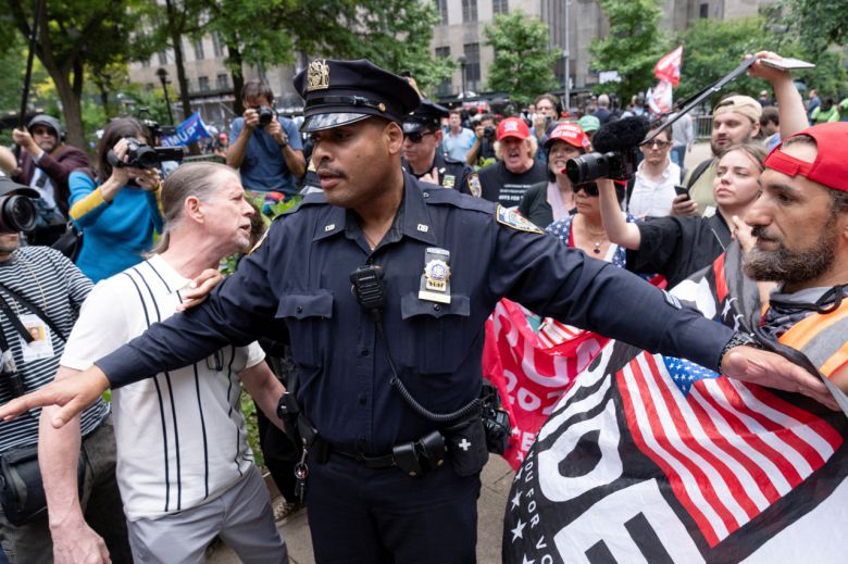 30일(현지시간) 미국 뉴욕 맨해튼 형사법원 앞에서 한 뉴욕 경찰이 트럼프 지지 시위대와 반대 시위대가 충돌하는 것을 막고 있다. 이날 뉴욕 맨해튼 주민 12명으로 구성된 배심원단은 법원에서 심리를 마친 뒤 트럼프 전 대통령이 받는 34개 범죄혐의에 대해 모두 유죄라고 평결했다. 연합뉴스
