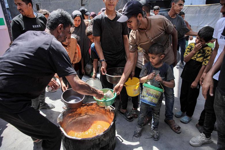 이스라엘과 하마스 간 팔레스타인 영토 분쟁이 계속되고 있는 가운데 13일(현지시간) 가자지구 북부 팔레스타인 난민 자발리아 캠프에서 사람들이 식량 지원을 받기 위해 줄을 서고 있다. [AFP]