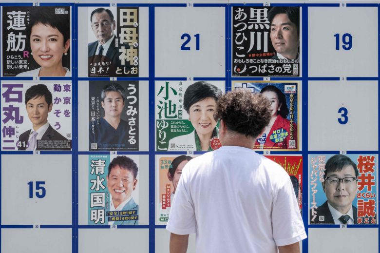7일 일본 도쿄에서 시민이 도쿄 도지사 선거 포스터를 보고 있다. [AFP]