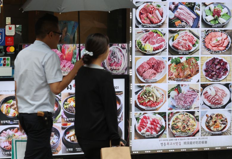 서울 중구 명동의 한 음식점 앞을 시민이 지나가고 있다.[연합]