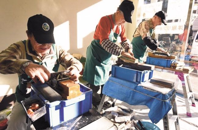 도쿄의 한 노인 작업 센터에서 작업자들이 숫돌에 가위와 식칼을 갈고 있는 모습. 건설 현장에서 야광봉을 흔드는 주름진 남성부터 계산대 점원이나 노인 간병인까지, 요즘 은발 노동자는 일본 어디에서나 볼 수 있다. 일본 인구의 약 27%가 65세 이상인 일본에서는 시니어 인력이 계속 일하면서 자신의 기술과 경험을 젊은 인력에게 전수할 수 있도록 장려하는 분위기가 확산되고 있다. [AFP]