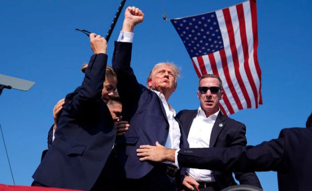 도널드 트럼프 전 미국 대통령이 지난달 13일 미 펜실베이니아주 버틀러에서 대선 유세 도중 암살 시도 총격을 당한 직후 경호원들에게 둘러싸여 연단을 내려오고 있는 모습. [AP]