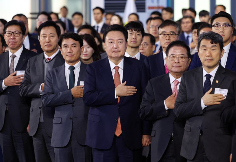 윤석열 대통령이 6일 강원도 춘천 송암스포츠타운 실내테니스장에서 열린 '2회 지방자치·균형발전의 날 기념식'에 참석해 국기에 경례하고 있다. 앞줄 왼쪽부터 대한민국시도지사협의회장인 박형준 부산광역시장, 오세훈 서울시장, 김진태 강원특별자치도지사, 윤 대통령, 우동기 지방시대위원장, 이주호 사회부총리 겸 교육부 장관. [연합]