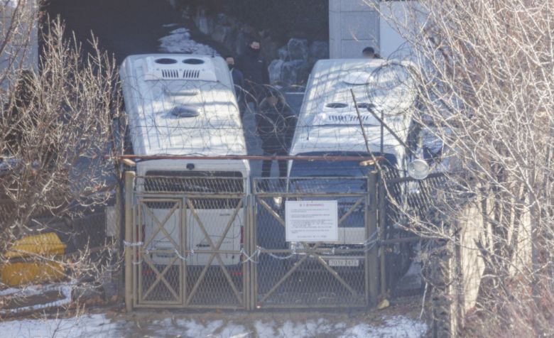 지난 9일 오전 서울 용산구 한남동 대통령 관저에서 경호처 직원이 철조망이 쳐진 쪽문을 버스로 벽을 치고 있다. [연합]
