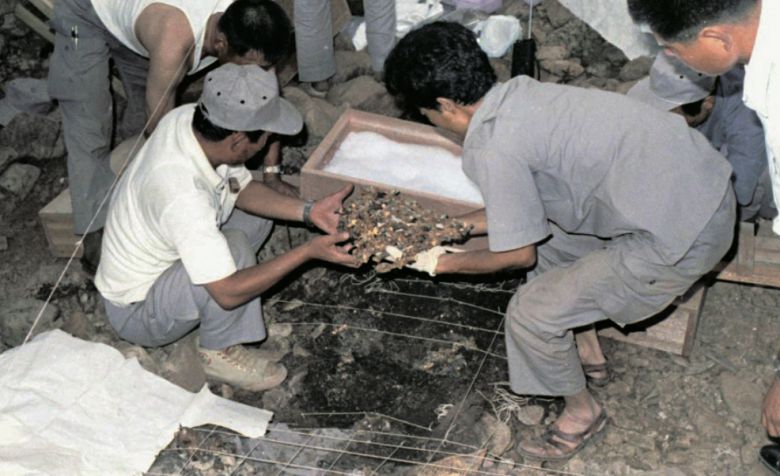 조사원들이 출토된 금관을 들어 올리는 모습. [국립경주문화유산연구소]