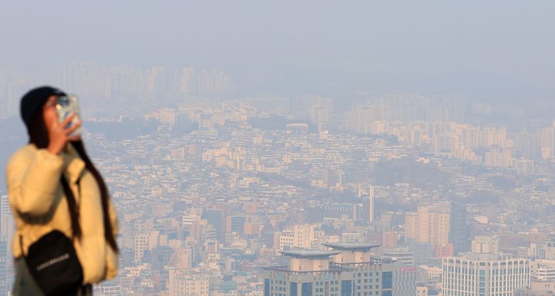 전국이 흐리고 미세먼지 농도가 ‘나쁨’ 수준을 보인 지난 6일 오후 서울 남산을 찾은 관광객 뒤로 도심이 안개와 미세먼지에 가려 있다. [연합]