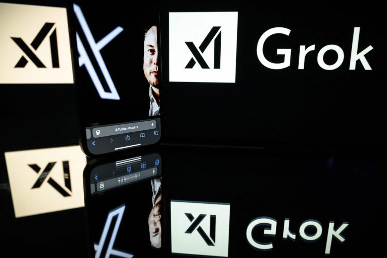 인공지능(AI) 스타트업 xAI의 AI 챗봇 ‘그록(Grok)’ 앱과 엑스(X·옛 트위터) 사이에 일론 머스크 테슬라 최고경영자(CEO)의 모습이 비춰지고 있다. [AFP]