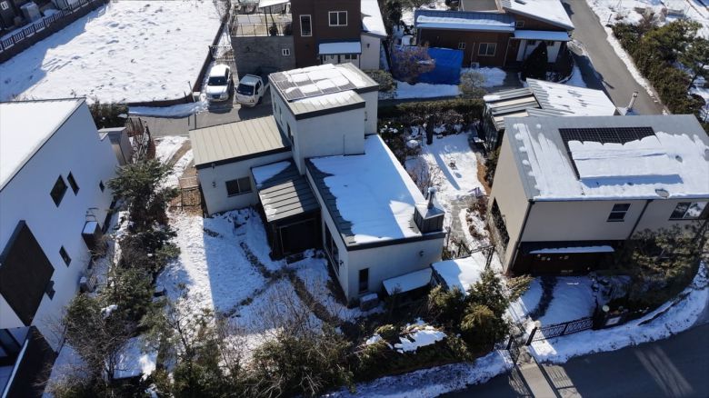 2층 단독주택 위로 눈이 소복하게 쌓여있다. 조경수로 둘러쌓인 모습. [윤병찬 PD]