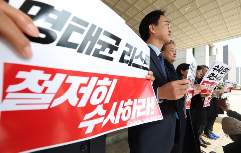 더불어민주당 명태균게이트 진상조사단이 14일 서울 서초구 대검찰청을 항의 방문하기 전 취재진 앞에서 손팻말을 들고 있다. <연합뉴스>