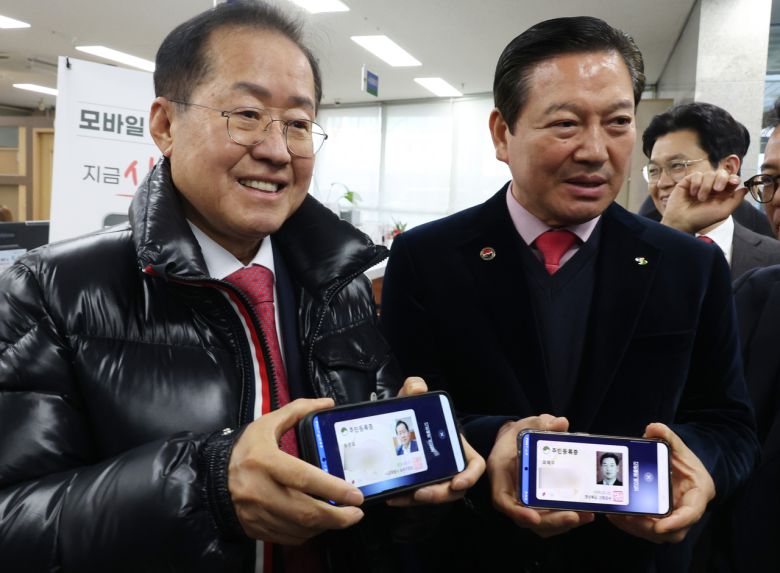 홍준표 대구시장이 모바일 주민등록증 발급 시작일인 14일 대구 남구 봉덕2동 행정복지센터에서 모바일 주민등록증을 발급받은 뒤 조재구 남구청장과 기념 촬영을 하고 있다. [연합]