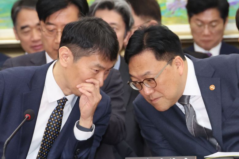 김병환(오른쪽) 금융위원장과 이복현 금융감독원장이 18일 국회 정무위원회 전체회의에서 대화하고 있다. [연합]