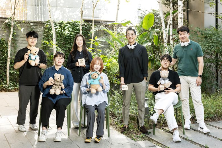 배익렬 스트레스솔루션 대표와 임직원이 전시에서 선보일 예정인 테디베어 수면 인형을 들고 포즈를 취하는 모습. [SK텔레콤 제공]