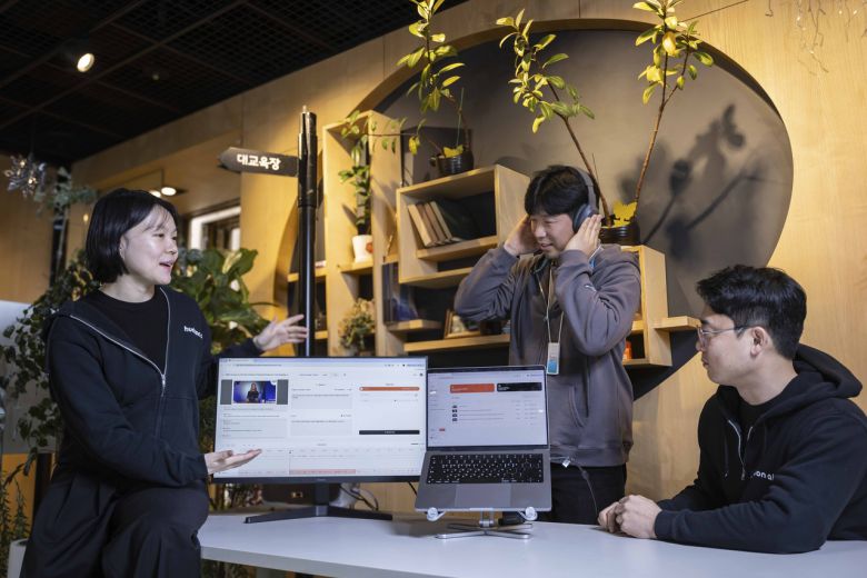 신현진 허드슨에이아이 대표와 임직원이 전시에 선보일 AI더빙 솔루션을 테스트하는 모습. [SK텔레콤 제공]