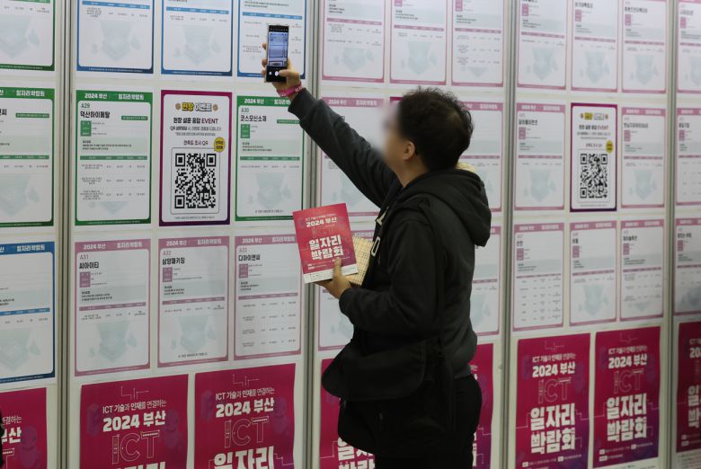 부산 해운대구 벡스코 제2전시장에서 한 구직자가 채용공고 게시판을 살펴보고 있다. [연합]