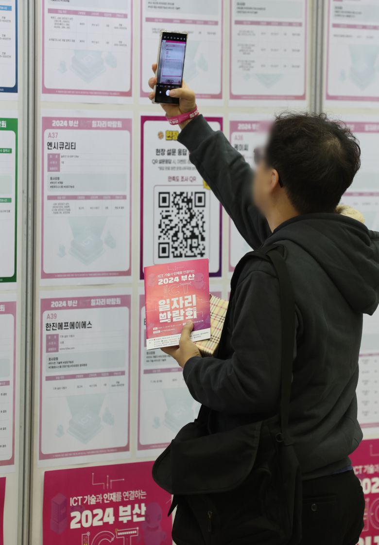 ICT 기술과 인재를 연결하는 2024 부산 ICT 일자리 박람회가 열린 20일 오전 부산 해운대구 벡스코 제2전시장에서 한 구직자가 채용공고 게시판을 살펴보고 있다. [연합]