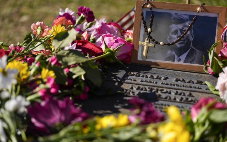 제35대 미국 대통령 존 F. 케네디의 사진과 이를 뒤덮고 있는 꽃들. [AP]