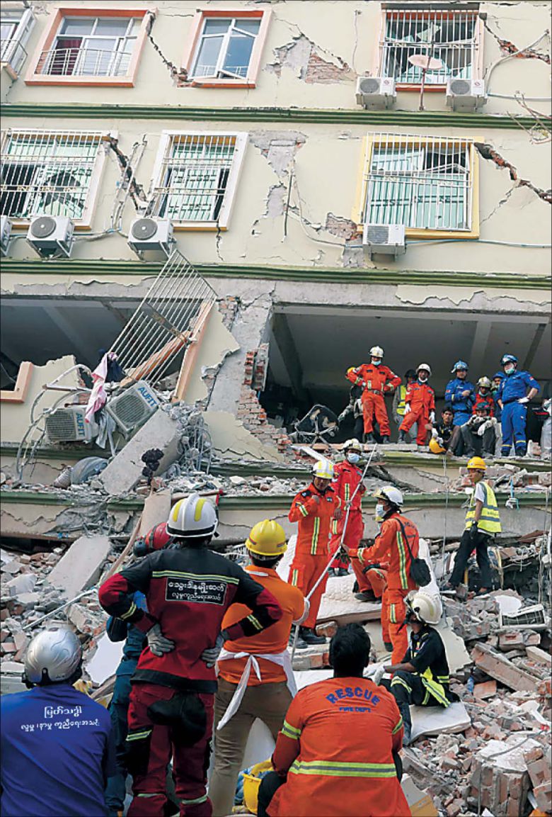 미얀마와 중국 구조대원들이 30일(현지시간) 미얀마 만달레이에 위치한 스카이 빌라에서 피해자들을 수색하고 있다. [EPA]