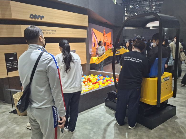 4일 고양 킨텍스에서 열린 2025 서울모빌리티쇼 부스를 찾은 관람객들이 HD현대 부스의 체험 프로그램을 즐기고 있다. [고양=김성우 기자]