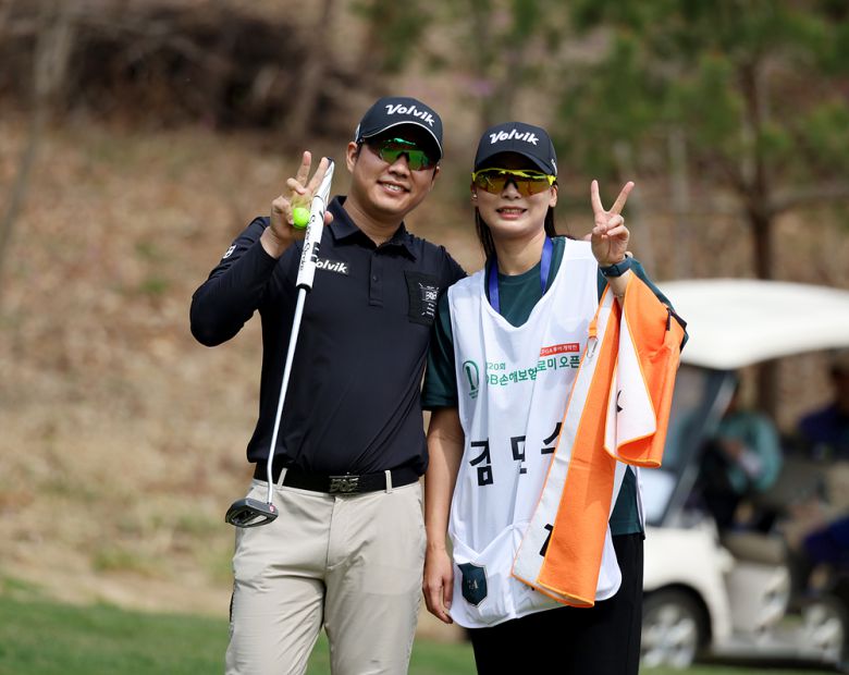 김민수가 KPGA 투어 DB손해보험 프로미 오픈 1라운드 8번홀에서 버디에 성공한 후 캐디를 맡은 아내 류아라 씨와 포즈를 취하고 있다.   [KPGA 제공]