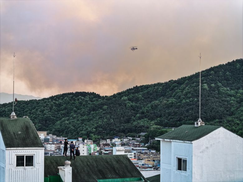 28일 오후 2시 1분께 대구 북구 노곡동 함지산에서 발생한 산불이 확산하고 있는 가운데 서변동 한 아파트 옥상에서 주민들이 산불 상황을 지켜보고 있다. [연합]