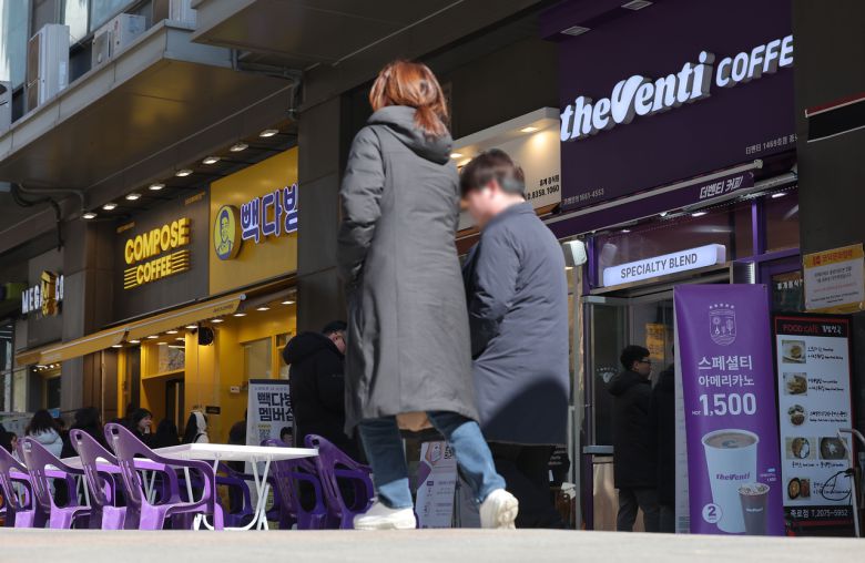 저가 커피 판매점이 밀집한 서울 종로구의 상가 앞으로 시민들이 지나가고 있다. [연합]