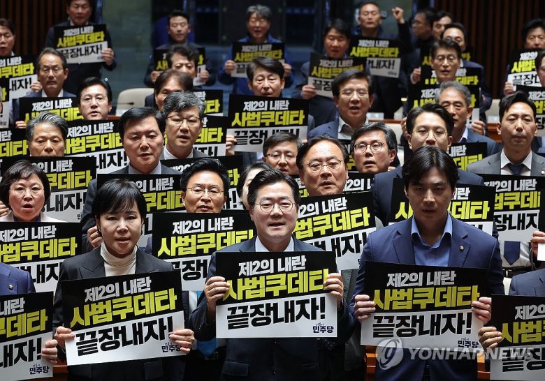 더불어민주당 박찬대 원내대표를 비롯한 의원들이 4일 국회에서 열린 긴급 의원총회에서 대법원 규탄 팻말을 들고 구호를 외치고 있다. [연합]