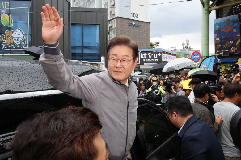 이재명 더불어민주당 대선 후보가 ‘골목골목 경청투어’ 사흘째인 3일 ‘동해안벨트’ 첫 방문지인 강원도 속초시 중앙재래시장에서 강원도민들을 만난 뒤 차에 올라 인사하고 있다.  [연합]