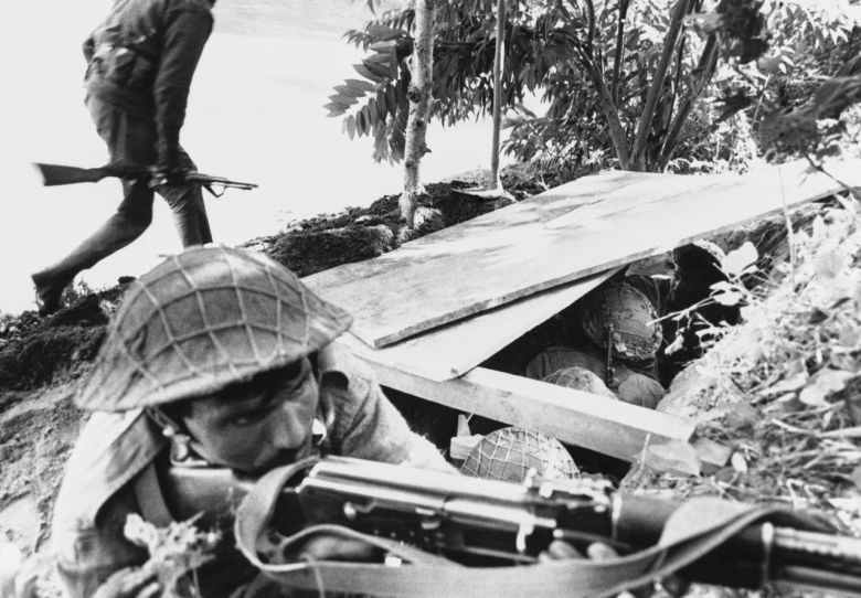 1971년 12월 동파키스탄 제소르 지역에서 인도군이 파키스탄 진지를 포격하는 동안 동료 병사가 소총을 겨누고 엄호 사격을 하고 있다. [AP]