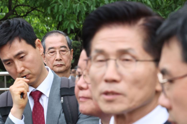 한덕수 무소속 대선 예비후보가 8일 서울 국회 사랑재에 위치한 커피숍에서 회동을 마친 후 김문수 후보의 백프리핑을 듣고 있다. 2025.5.8 [공동취재] <연합뉴스>