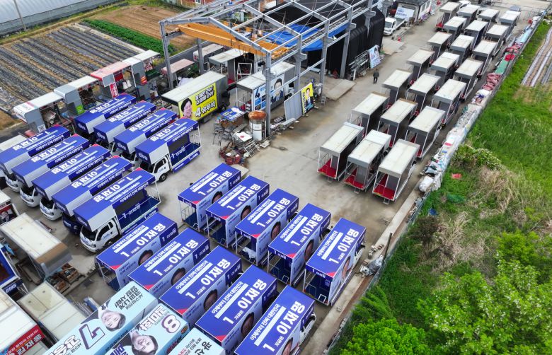 제21대 대통령 선거 후보 등록 마감일인 11일 광주 광산구에 위치한 차량광고업체 한양E&C에 선거 유세에 투입될 차량이 놓여 있다. 더불어민주당 유세 차량(왼쪽)과 국민의힘 유세 차량의 모습 [연합]