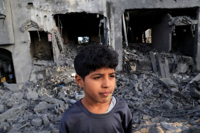 15일(현지시간) 가자지구 남부 칸 유니스에서 한 남자 아이가 이스라엘의 주택 공격 현장한가운데 서 있는 모습. [로이터]