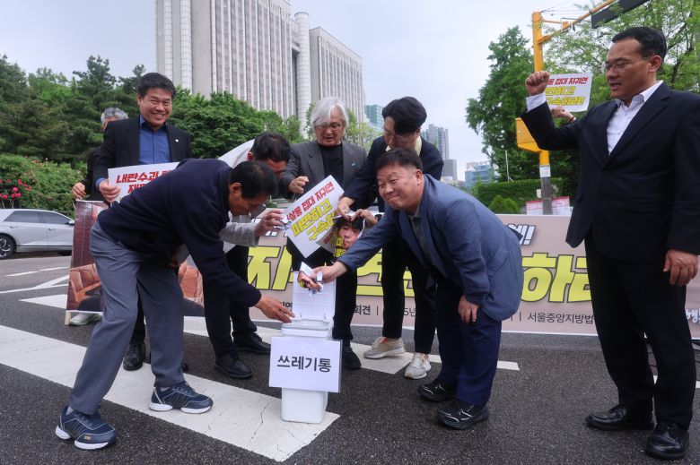 촛불행동 회원들이 16일 서울 서초구 서울중앙지방법원 앞에서 열린 지귀연 부장판사 면담 요청 기자회견에서 지 부장판사를 규탄하는 퍼포먼스를 하고 있다. [연합]