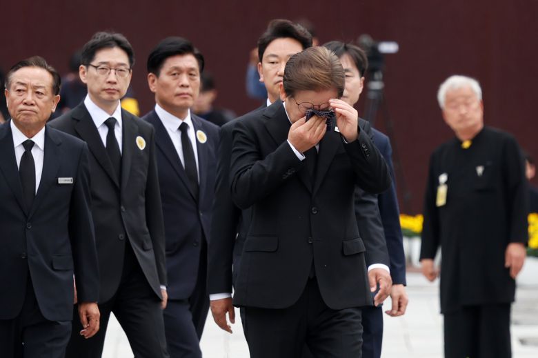 이재명 더불어민주당 대선 후보가 23일 경남 김해시 진영읍 봉하마을을 방문해 노무현 전 대통령 묘역 참배 및 헌화를 마친 뒤 눈물을 훔치고 있다. 2025.5.23 [공동취재][연합]