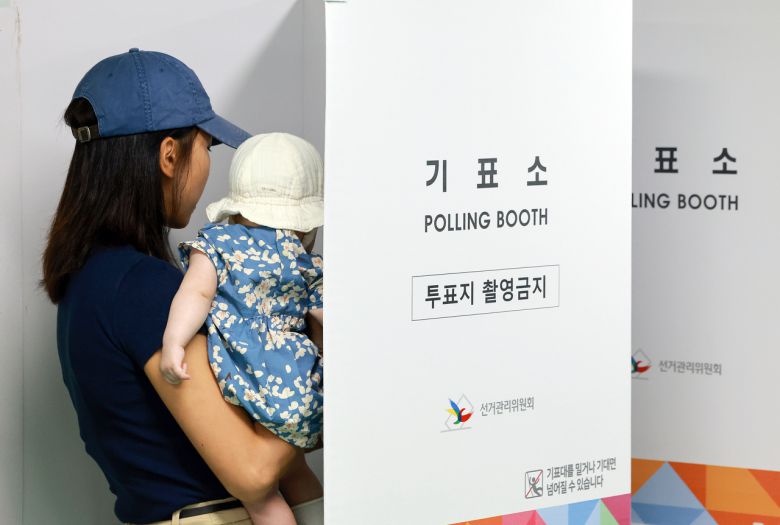 21대 대통령 선거 사전투표 둘째날인 지난달 30일 서울 관악구 낙성대동주민센터에 마련된 낙성대동사전투표소에서 아이를 안은 유권자가 투표하고 있다. 사진은 기사 내용과 직접적 관련 없음. [연합]