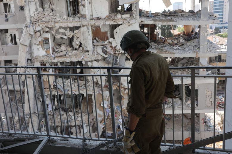 지난 15일(현지시간) 이란의 미사일 공격 현장에서 이스라엘 군인이 잔해를 둘러보고 있다. [AFP]