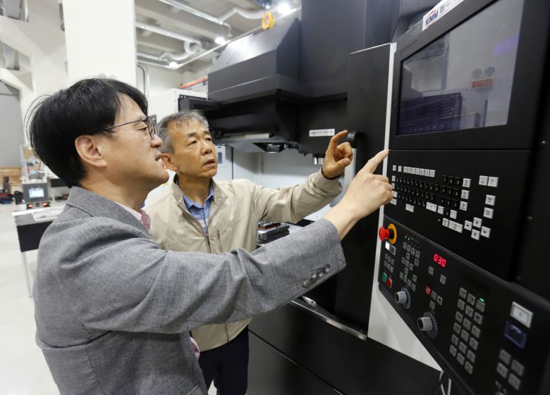 송창규(왼쪽) 한국기계연구원 박사가 K-CNC 시스템을 살펴보고 있다. [한국기계연구원 제공]