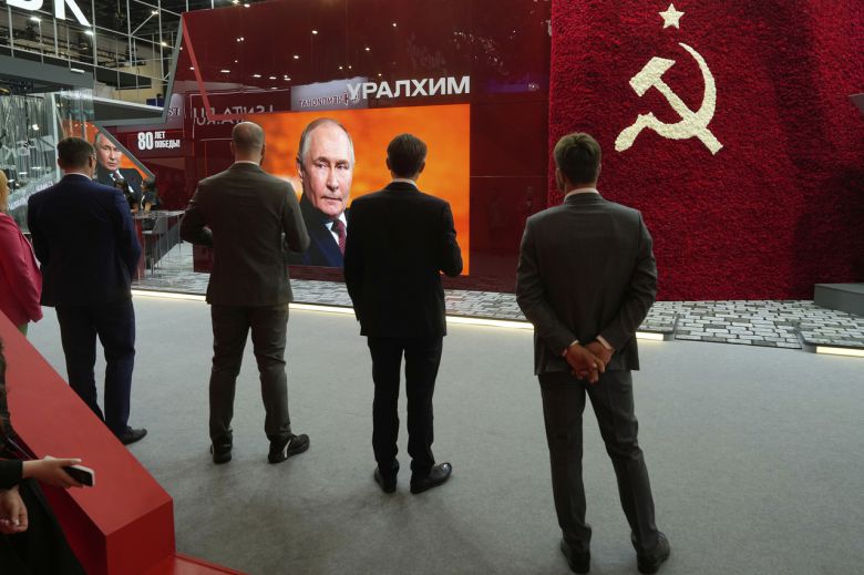 블라디미르 푸틴 러시아 대통령이 20일(현지시간) 상트페테르부르크 국제경제포럼(SPIEF) 본회의에서 발언하는 장면을 행사 참가자들이 TV를 통해 바라보고 있다. [AP]