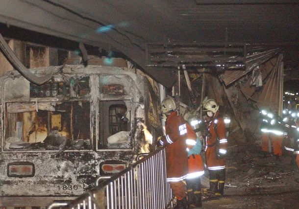 소방대원들이 대구지하철 화재 현장에서 전소된 전동차를 살펴보고 있다. [연합]