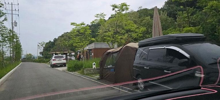 용인시 처인구 한 자전거 도로 옆 공중화장실 인근에 차량을 주차시키고 텐트를 친 모습. [보배드림 갈무리]
