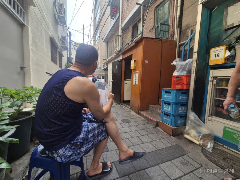9일 오전 서울 종로구 돈의동 쪽방촌 골목에 한 주민이 나와 부채질을 하고 있다. 김도윤 기자.
