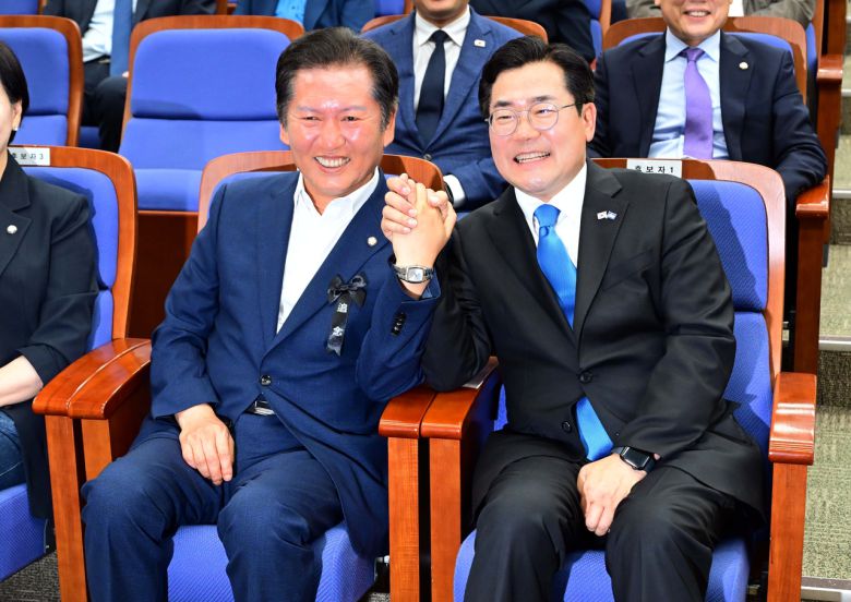 더불어민주당대표 후보인 정청래(왼쪽)·박찬대 의원. 사진은 지난달 24일 오후 서울 여의도 국회에서 열린 의원총회에 참석해 자리에 앉아 손을 맞잡은 모습. 이상섭 기자