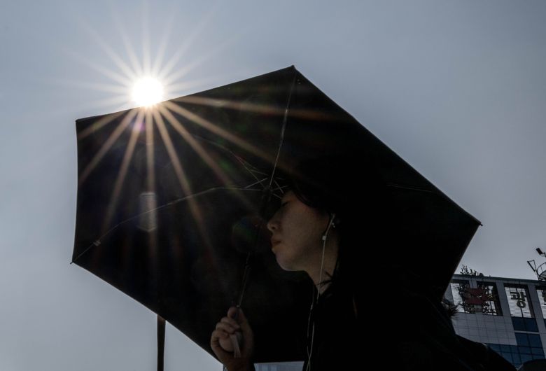 서울 지역에 폭염경보가 발효 중인 8일 오전 서울 종로구 세종대로 사거리에서 한 시민이 양산으로 뜨거운 햇살을 가리며 출근길을 서두르고 있다. 임세준 기자