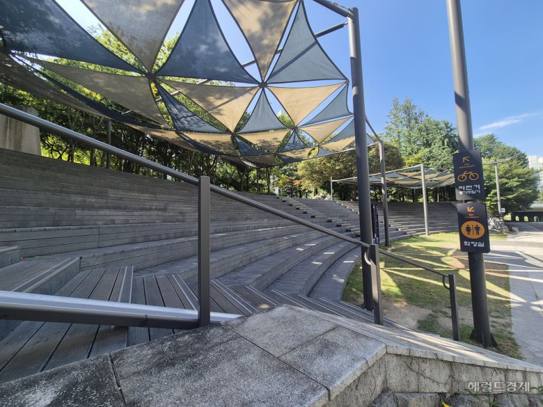 서울 노원구 당현천 인근의 한 야외 무더위 쉼터. 계단 위에는 검은색 천막이 설치돼 있으나 시민들은 그늘 형성만으로는 폭염이 지속되는 상황에서 더위를 피하기 어렵다고 했다. 김도윤 기자.