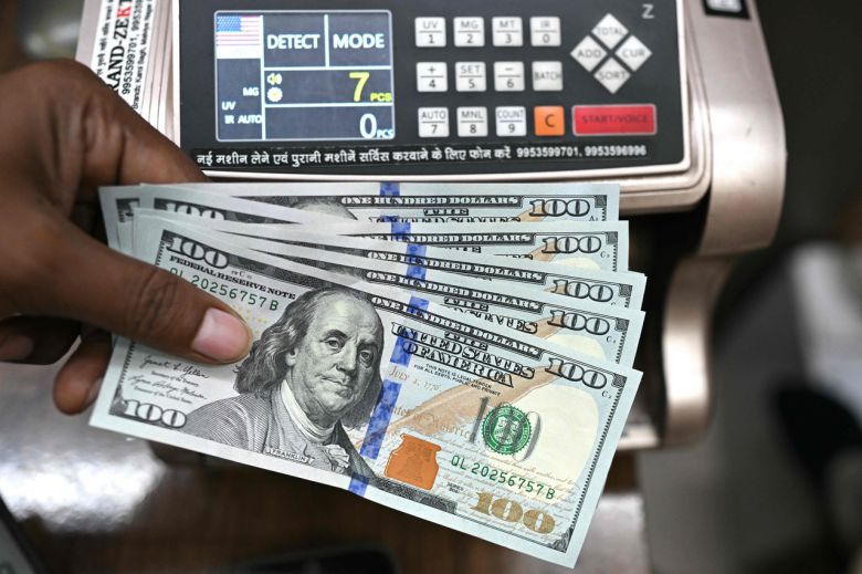 한 환전소에서 근무하는 직원이 미국 달러 지폐를 들고 포즈를 취하고 있다. [AFP]