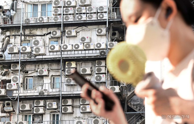 연일 푹푹 찌는 폭염으로 서울 지역이 10일째 열대야가 이어지는 가운데 지난 9일 오전 한 시민이 서울 중구 남대문 인근에 있는 건물 외벽에 줄지어 걸린 에어컨 실외기 앞을 지나가고 있다. [사진=이상섭 기자/babtong@]