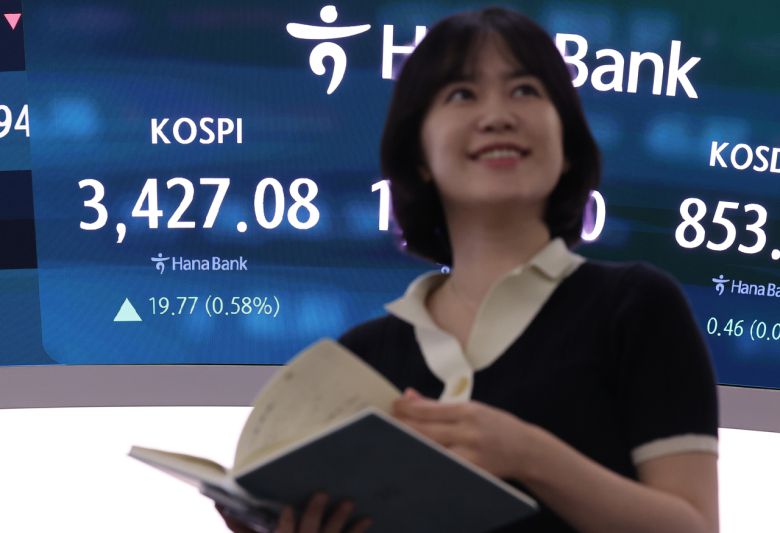 코스피가 상승 출발한 16일 서울 중구 하나은행 딜링룸에서 한 딜러가 활짝 웃고 있다. [연합]