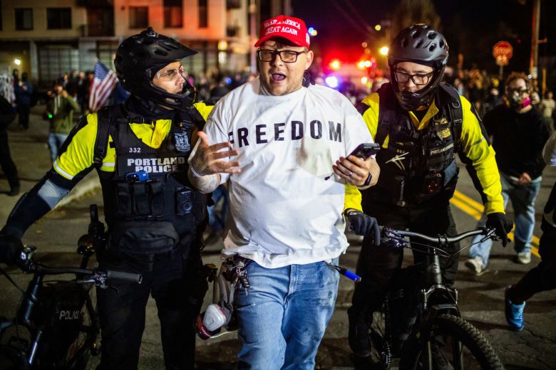 5일(현지시간) 오리건주 포틀랜드에 위치한 미국 이민세관집행국(ICE) 시설 근처에서 포틀랜드 경찰관들이 한 남성과 대화하고 있다. [AP]