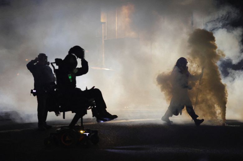 4일 오리건주 포틀랜드에 위치한 미국 이민세관집행국(ICE) 본부 근처에서 시위대를 해산시키기 위해 최루가스가 사용되자 사람들이 마스크를 착용하고 있다. [로이터]