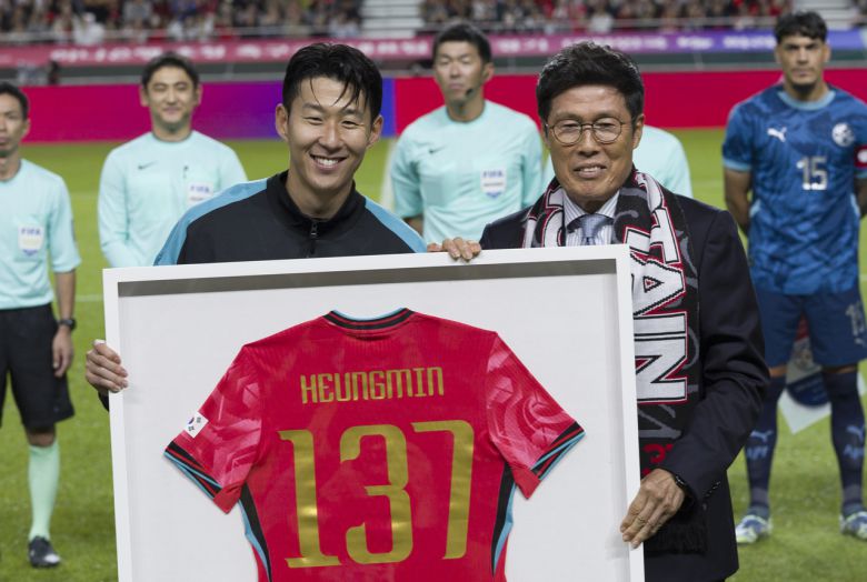 손흥민이 차범근 전 감독으로부터 한국 선수 최다 A매치 기념 유니폼을 전달받고 기념촬영을 하고 있다.   [뉴시스]